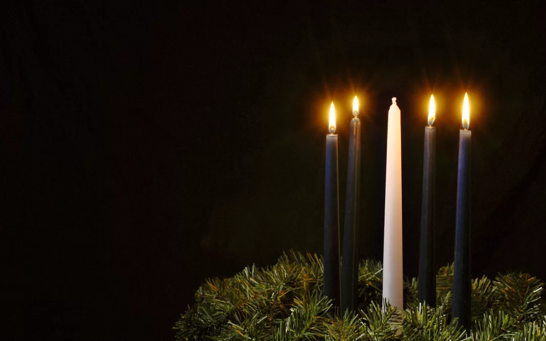 Photo of an advent wreath with four candles lit.