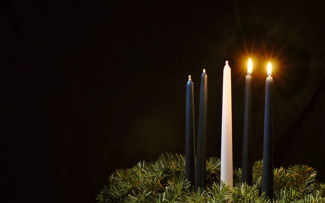Two candles lit on an Advent wreath.